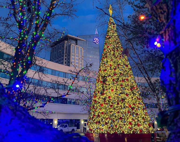 Night time view of a well decorated and lit Christmas Tree with Turning Stone Casino & Resort in the background